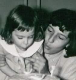 A person and a child blowing out candles