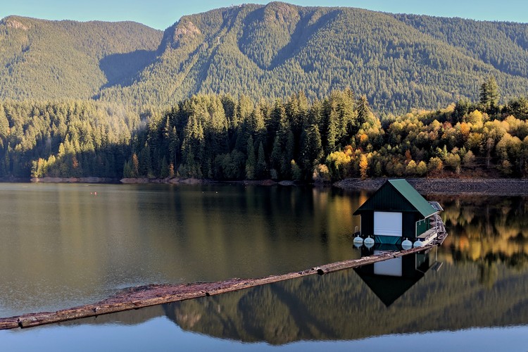 Green house on Capilano Lake with Cleveland Dam in North Vancouver