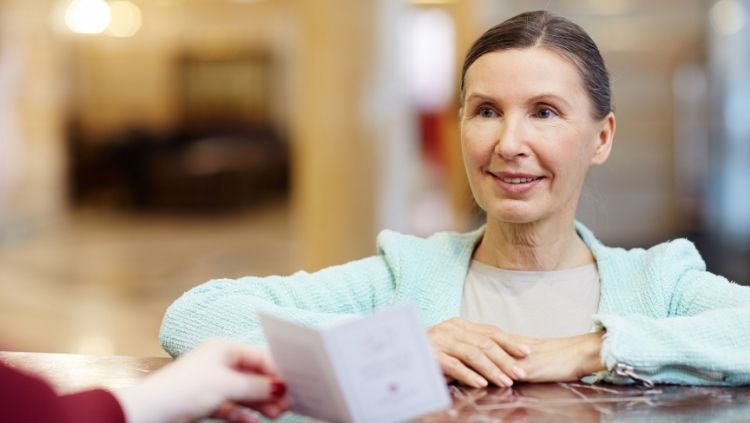 woman standing at counter purchasing travel insurance for seniors