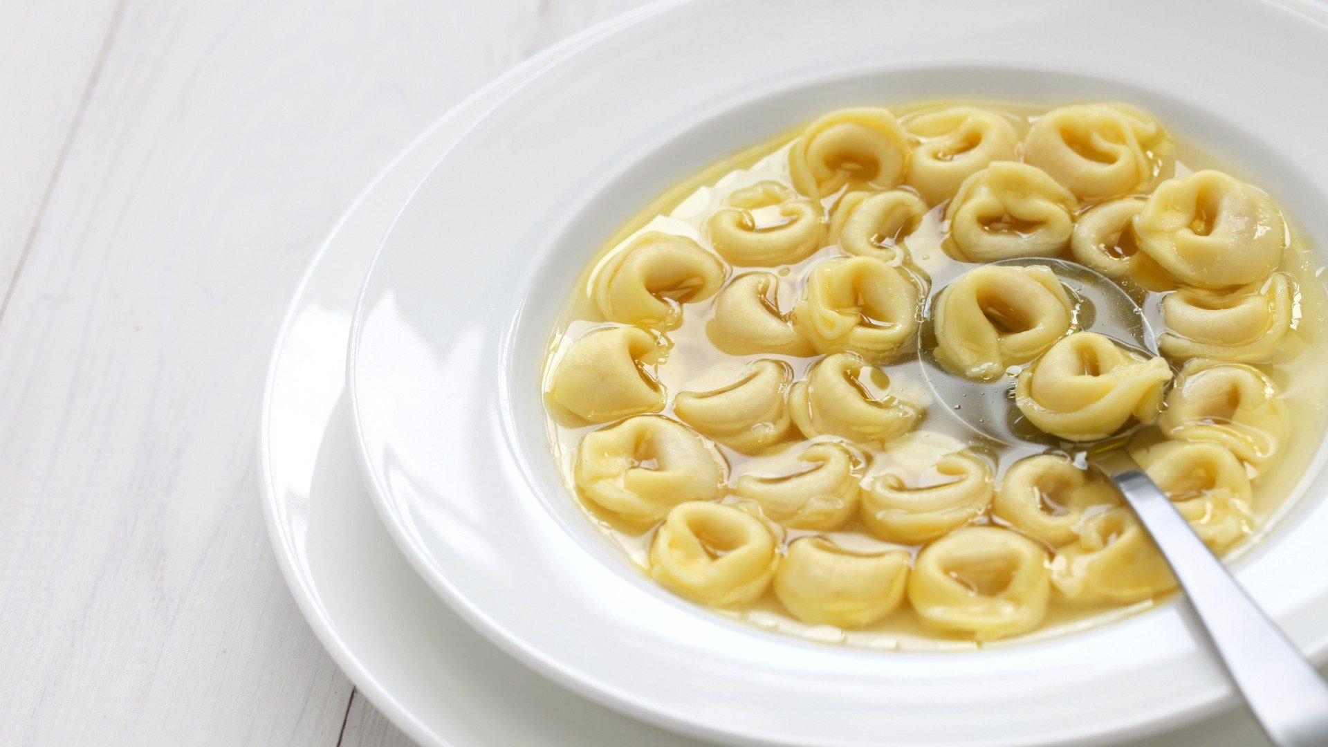 A close up of a dish of Tortellini in brodo, a typical dish of Italian cuisine.