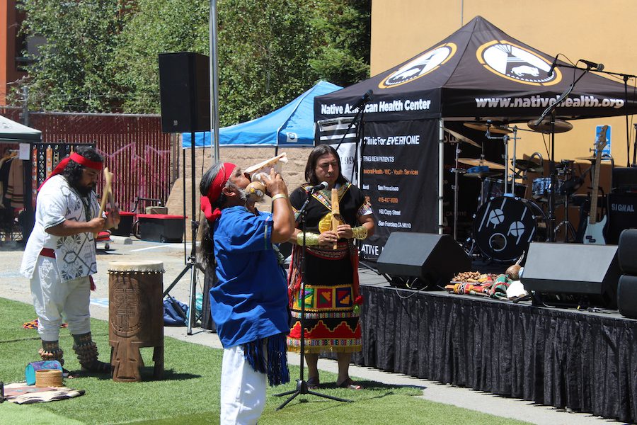 Dancer blows a conch shell at Oakland, California's Indigenous Red Market.