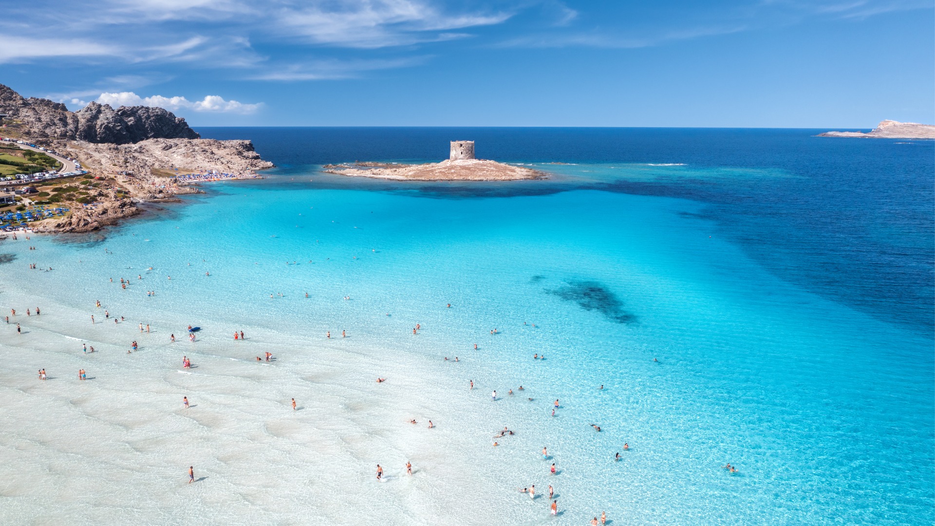 A stunning panoramic view of the crystal-clear waters at La Pelosa Beach in Sardinia.