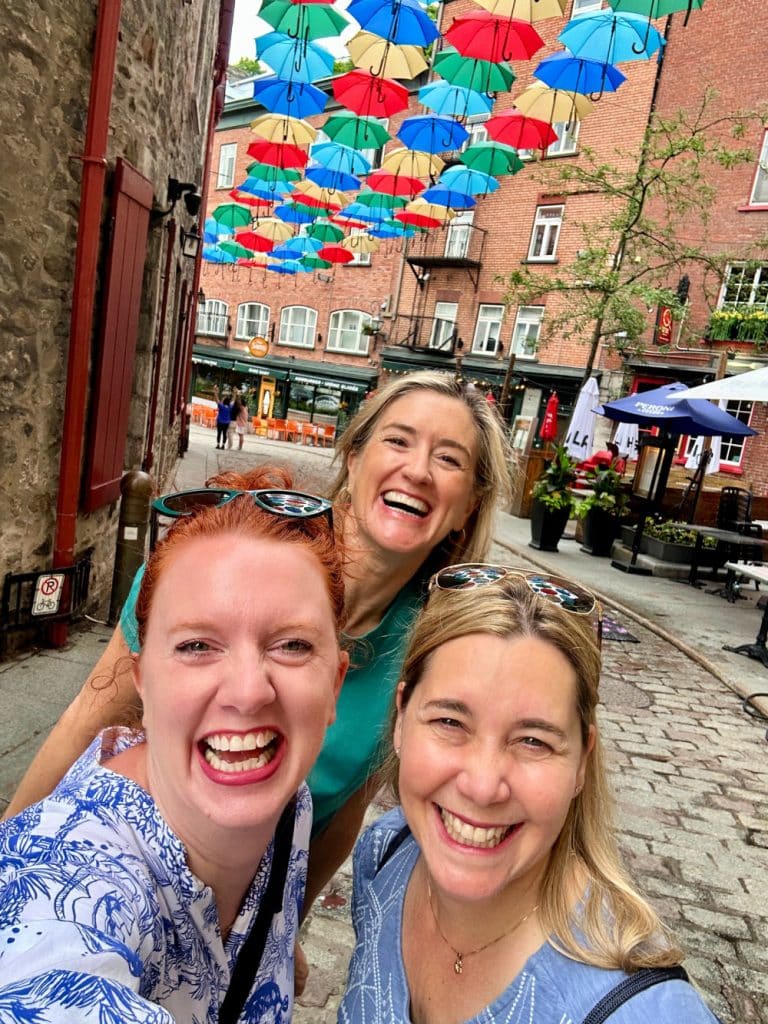 ladies smiling on umbrella alley in quebec city in summer