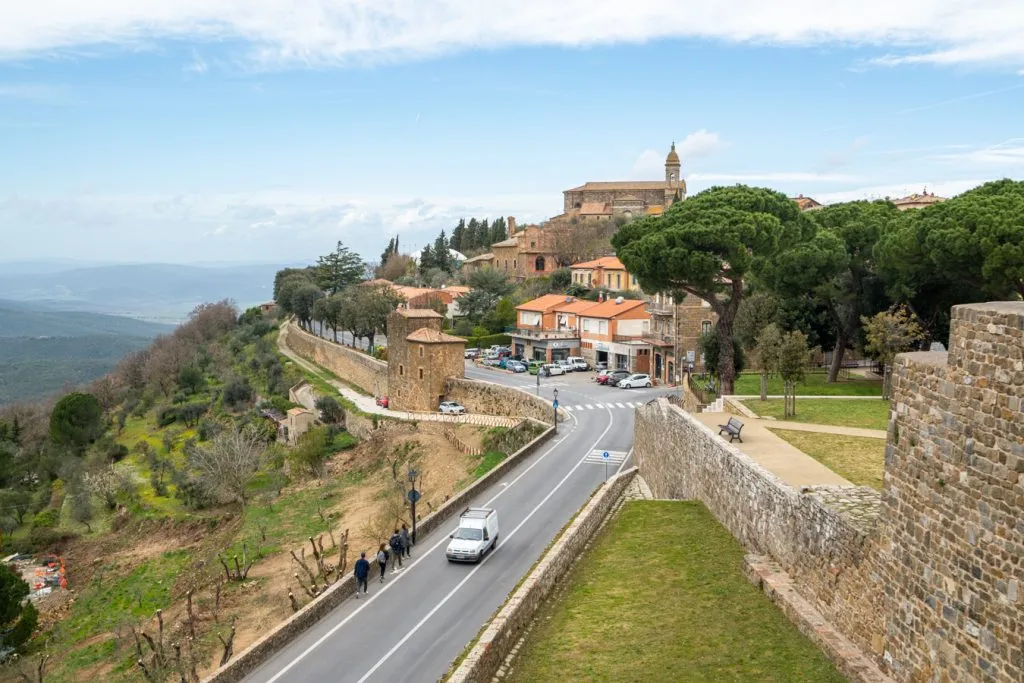 View of Montalcino, Tuscany, with cars driving down a road in the foreground