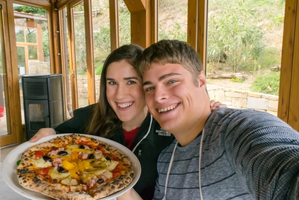 Kate Storm and Jeremy Storm holding up their pizzas at a Tuscany cooking class near Florence