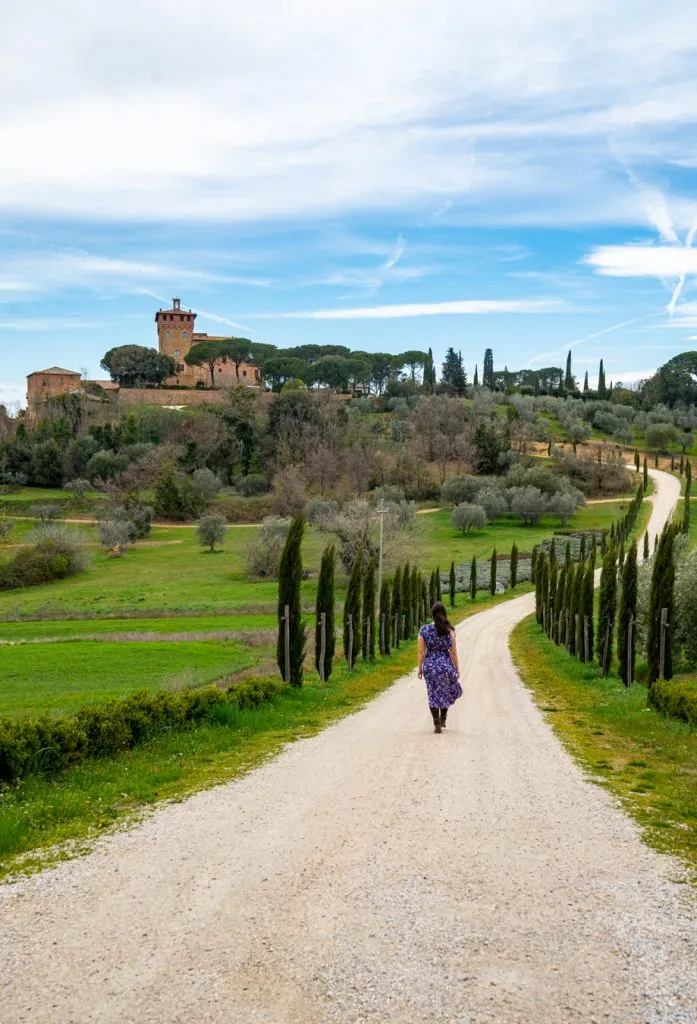 Kate Storm strolling on a dirt road in the Tuscan countryside