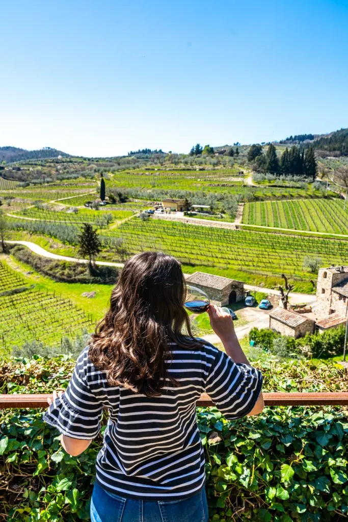 Kate Storm enjoying wine while overlooking Tuscany's vineyards