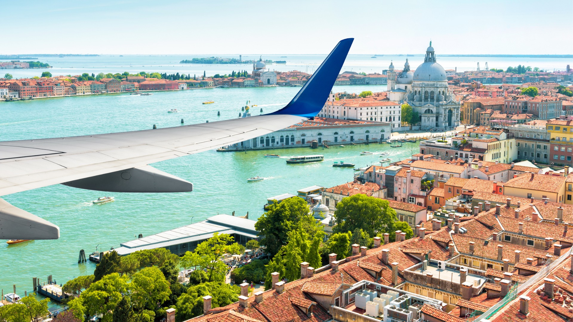 An aerial view of Venice with a plane wing in the foreground.