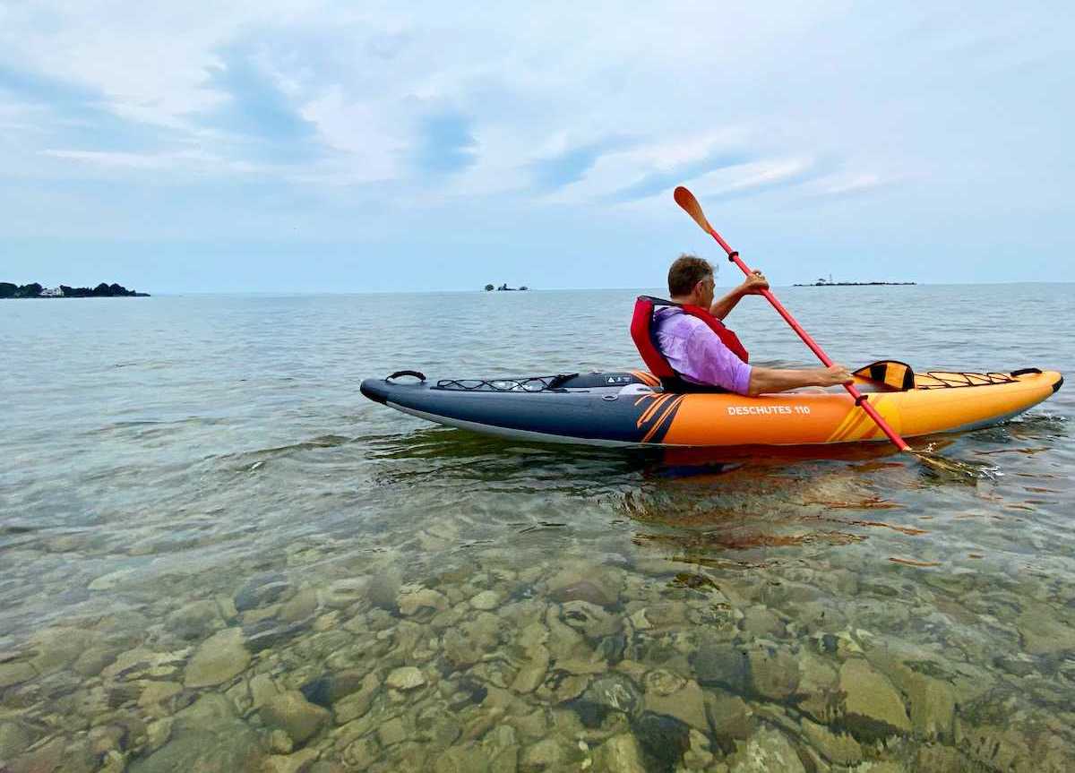 Man kayaking over shallow water in Collingwood.