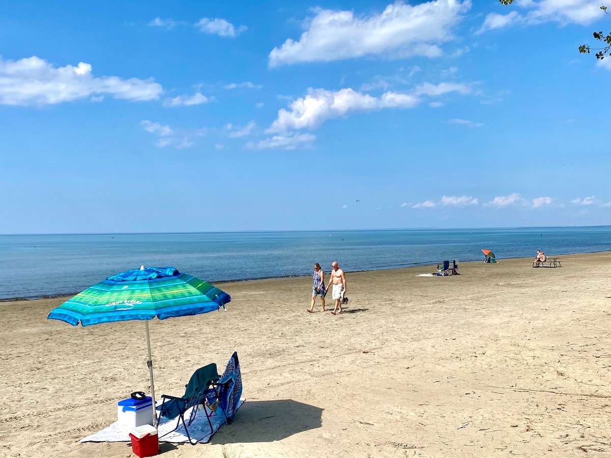 Wasaga Beach with a blue sun umbrella.