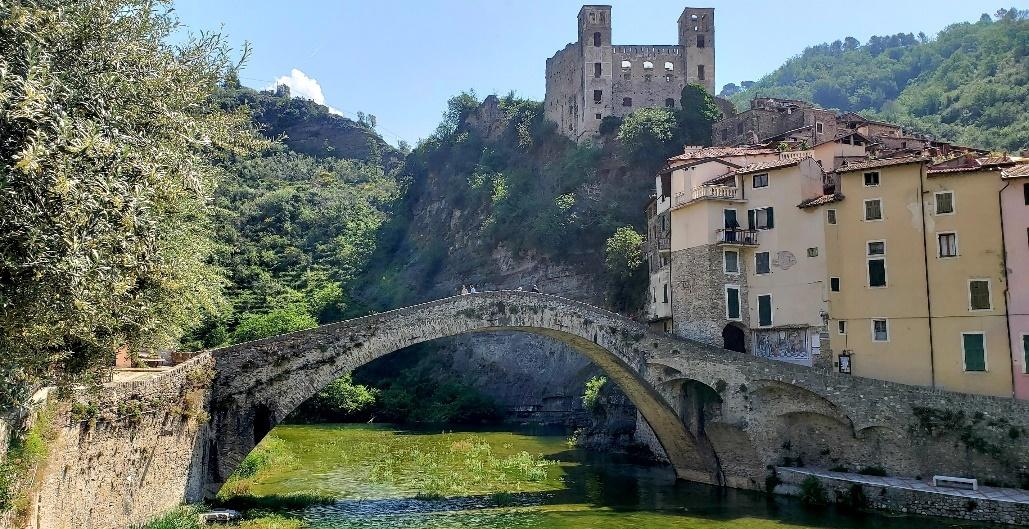 A stone bridge over a river with a castle in the background