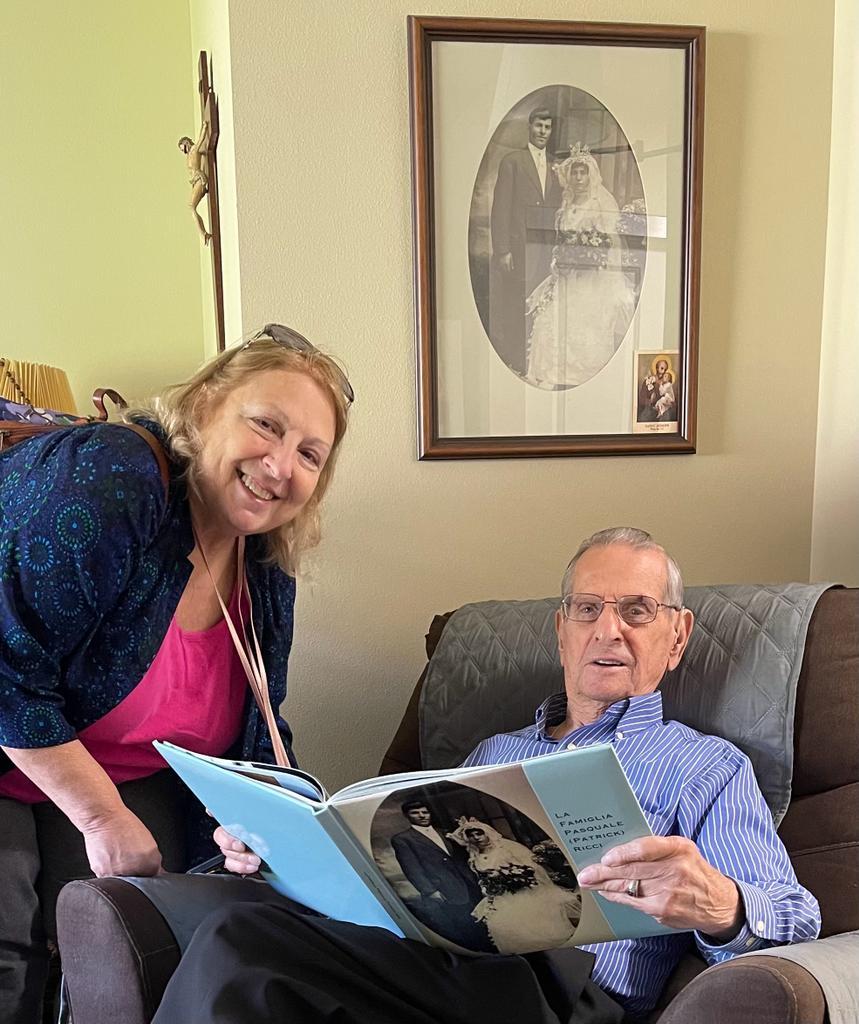 A person and person sitting on a couch reading a book