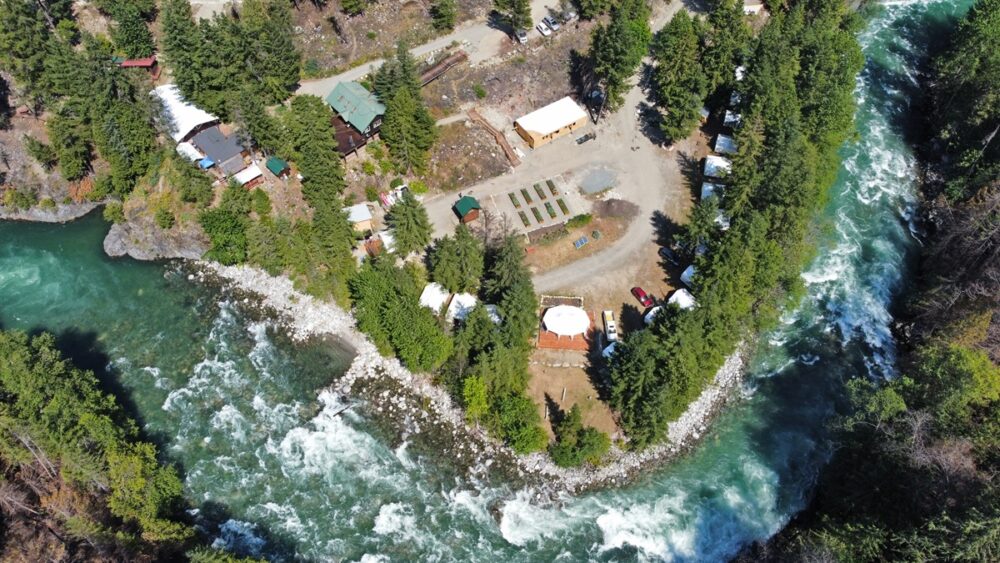 Drone view of the lower and mid levels of REO Rafting next to jade-green Nahatlatch River