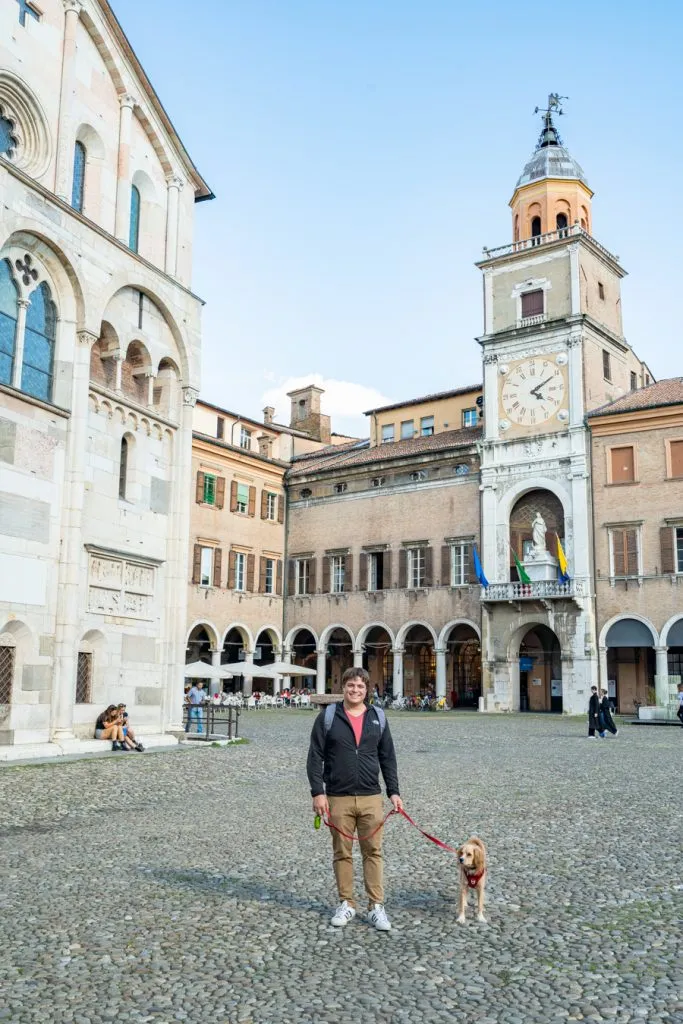 jeremy storm and ranger storm standing in front of clock tower in modena italy, one of the best places to visit in emilia romagna