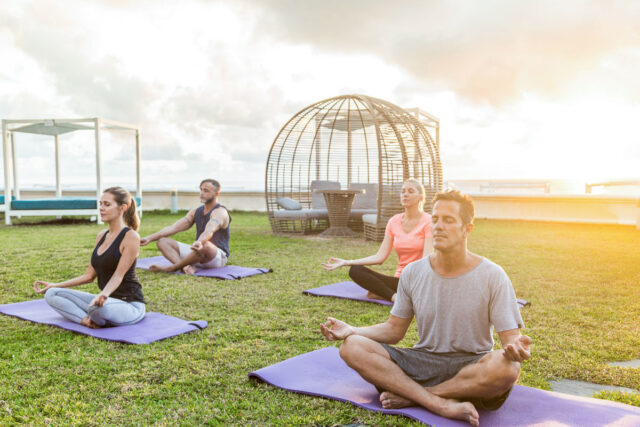 Couples participating in outdoor yoga