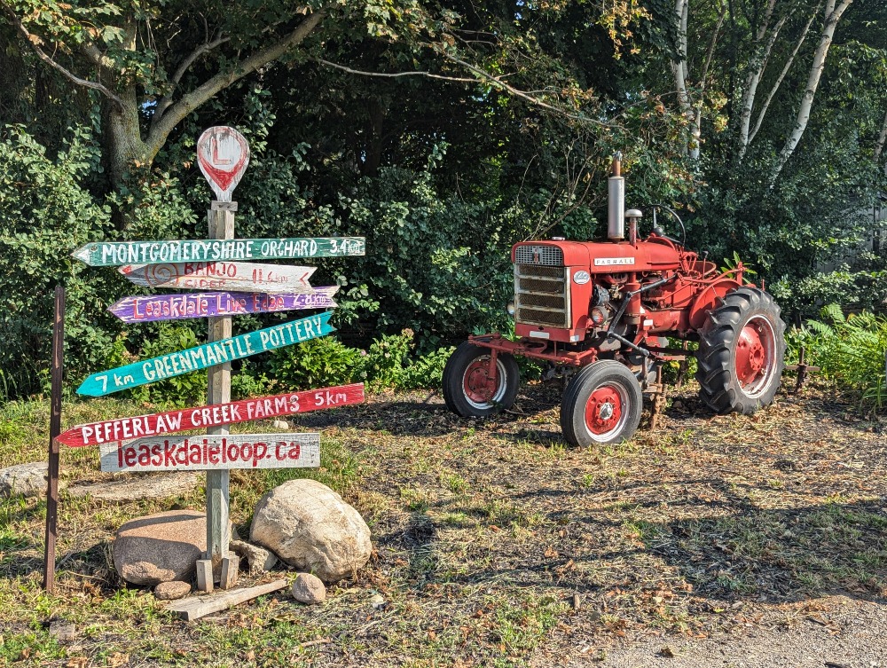 Leaskdale Loop sign next to an old farm tractor.