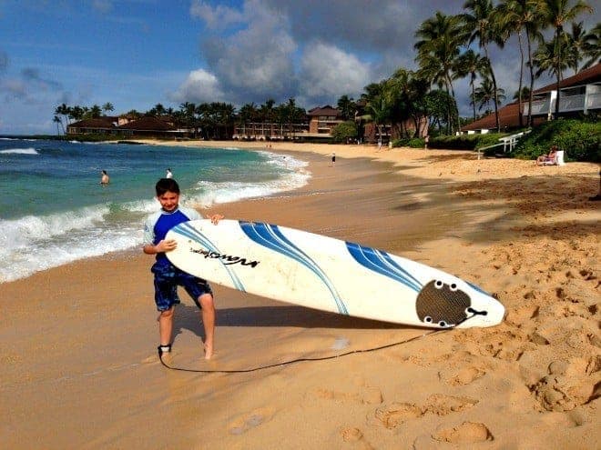 Boy holding surfboard in Kauai