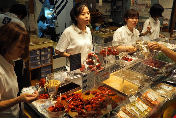 eating red octopus on a stick at Nishiki Market in Kyoto Japan