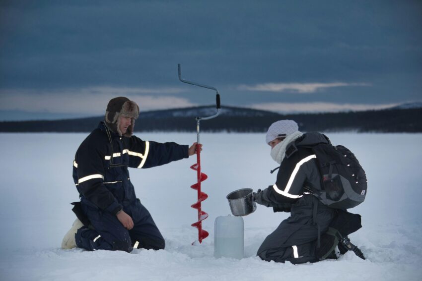 A man and a woman drilling on snow