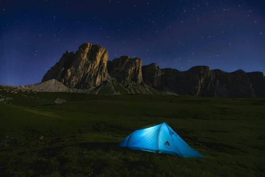 A blue dome tent near a mountain