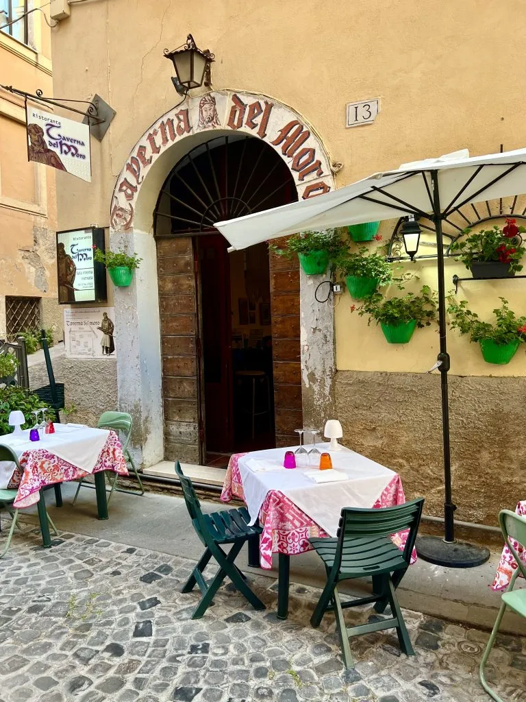 Front facade of a restaurant in Civitavecchia, Italy, with tables set for dinner