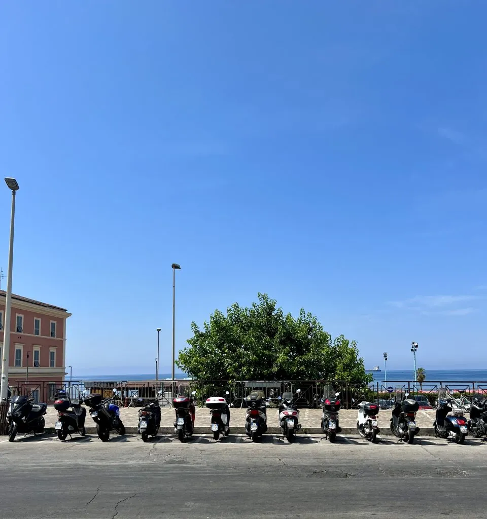 Motorcycles parked in Civitavecchia, Italy, with the sea in the background