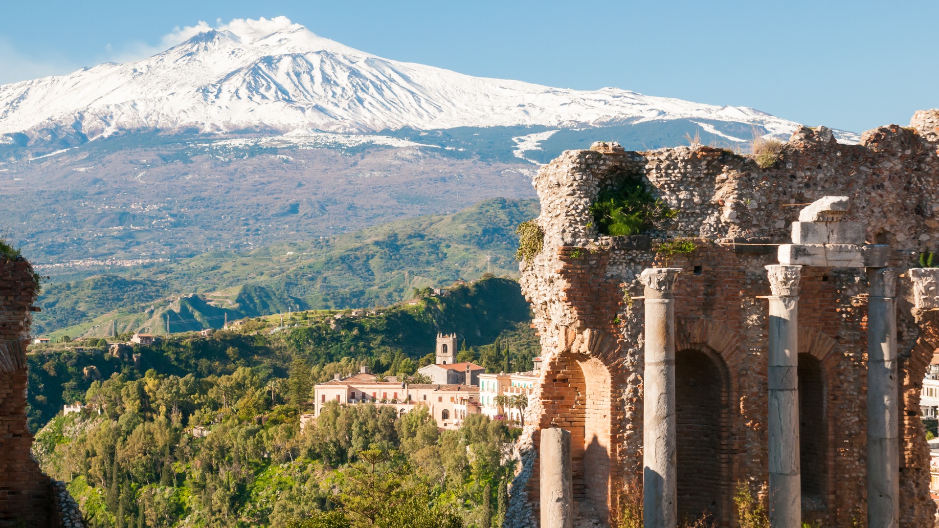 Ancient columns in Taormina with the snow-capped Mt Etna in the background.