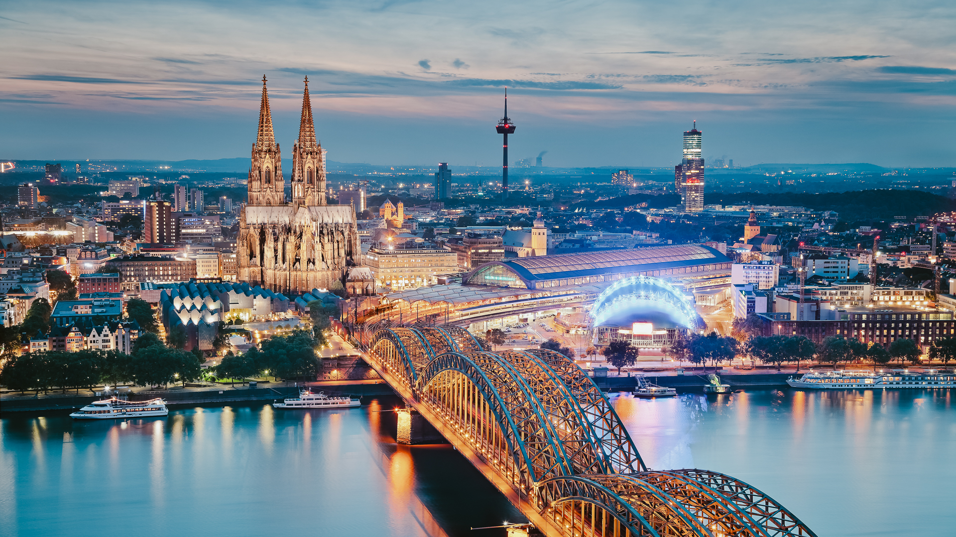 A twilight view of Cologne Cathedral against the evening sky.