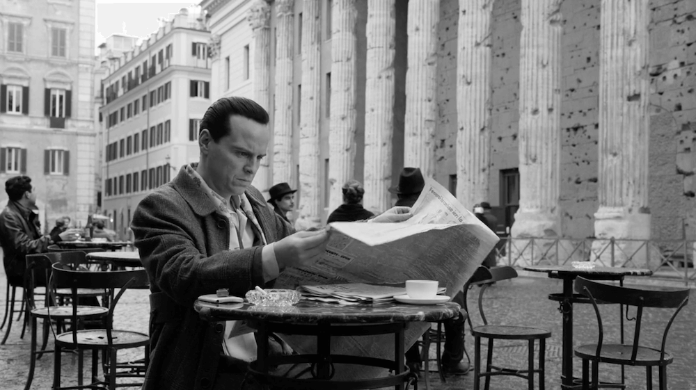 Tom Ripley reads the paper while drinking coffee outside the Temple of Hadrian. Image credit: Netflix