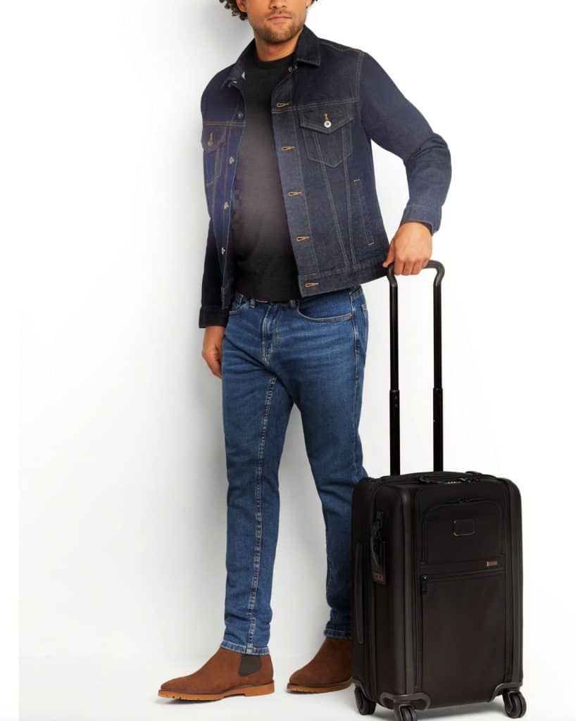 Man wheeling a black TUMI suitcase