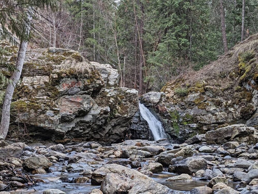 Looking towards Mill Creek Falls, a small cascade framed by rocks in a canyon