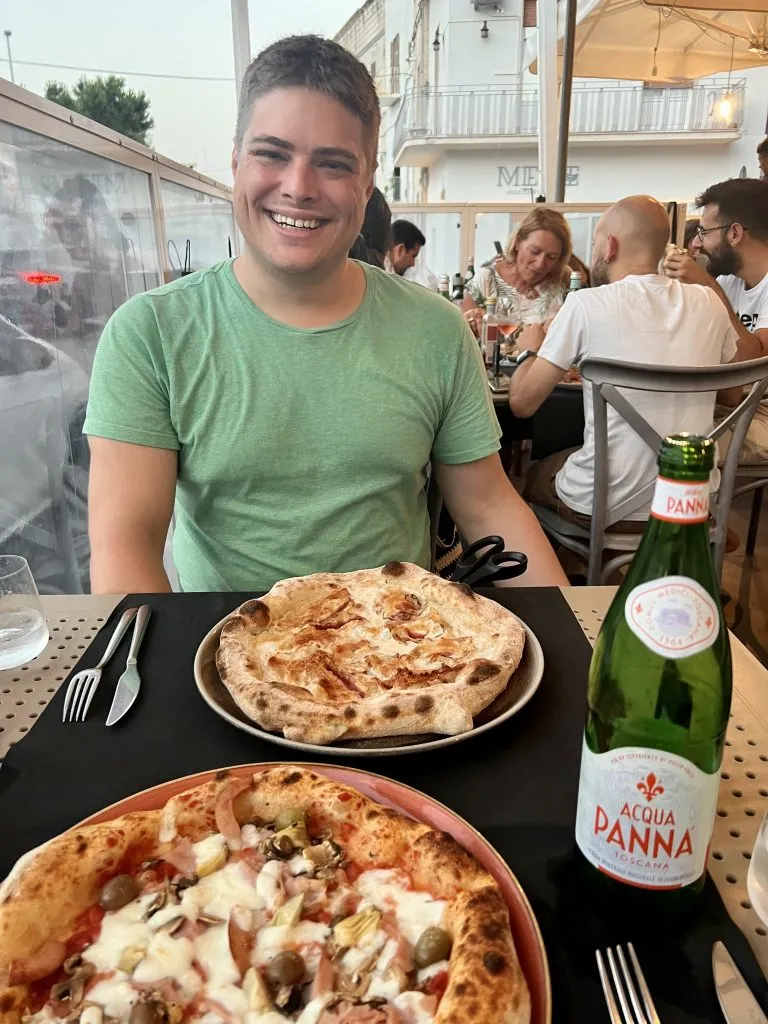 Jeremy Storm with two Italian pizzas in front of him in Italy