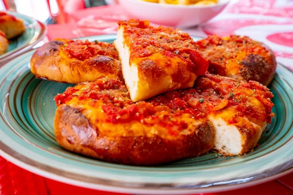 Sicilian pizza served on a green plate in Palermo