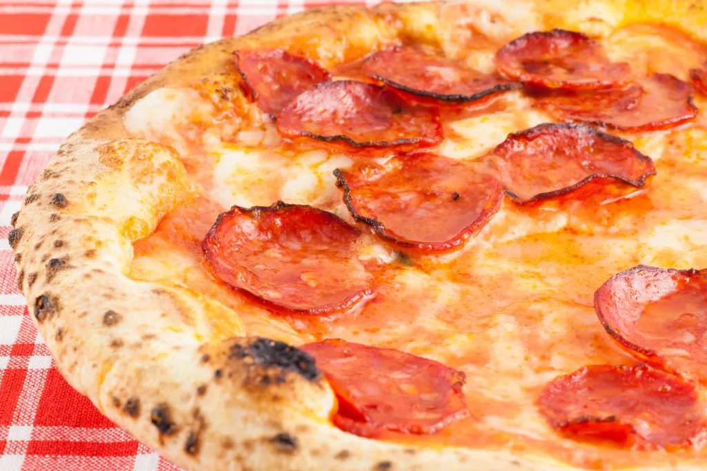 Pizza Diavola presented on a red checkered tablecloth