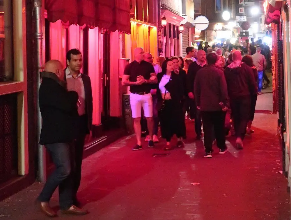 Tourists in De Wallen observing window brothels