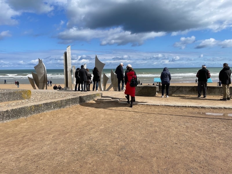 Omaha Beach Braves sculpture with people standing around in late autumn