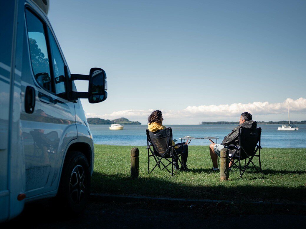 A couple enjoying their time outside of their motorhome at a freedom campsite