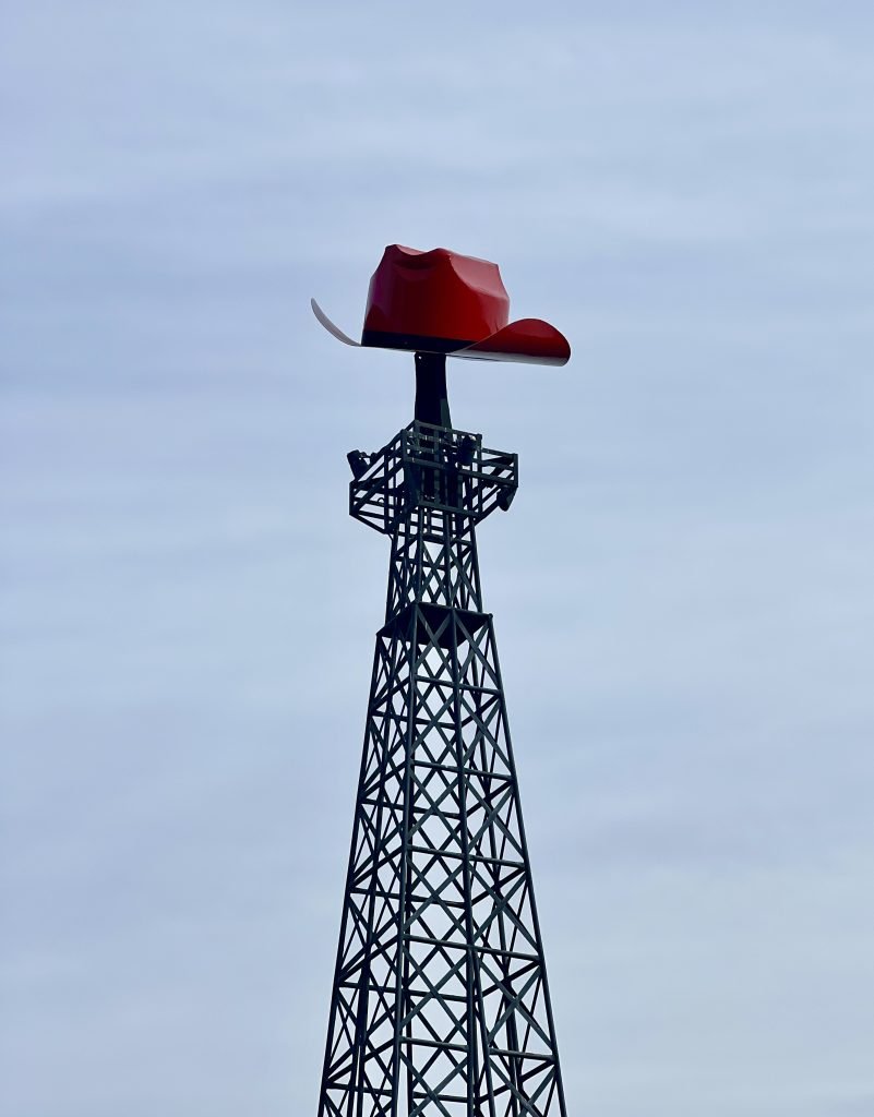 Close up of the top of the Eiffel Tower in Paris, TX with a red cowboy hat on top