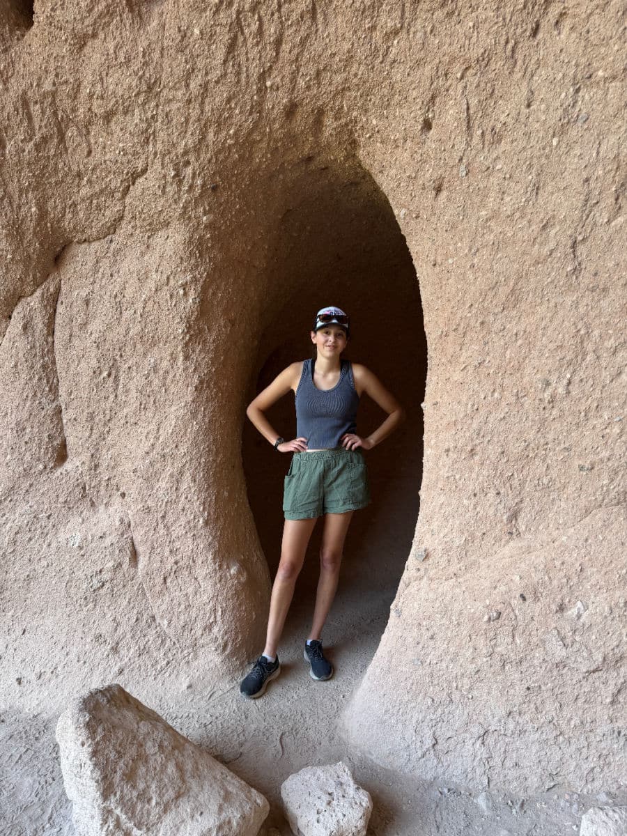 Person standing in a cavate at Bandelier National Monument