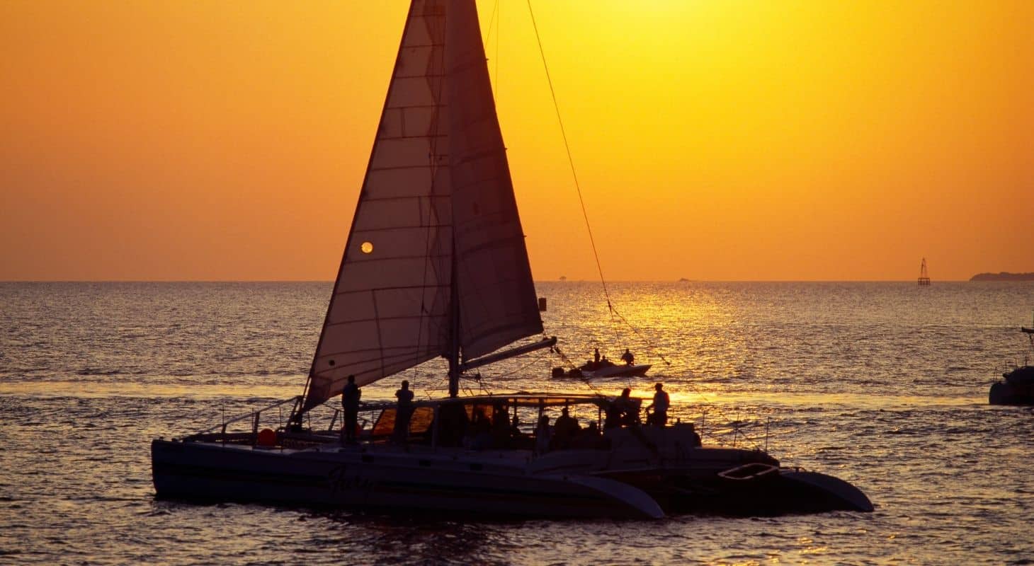 A sailboat sailing on the water at sunset