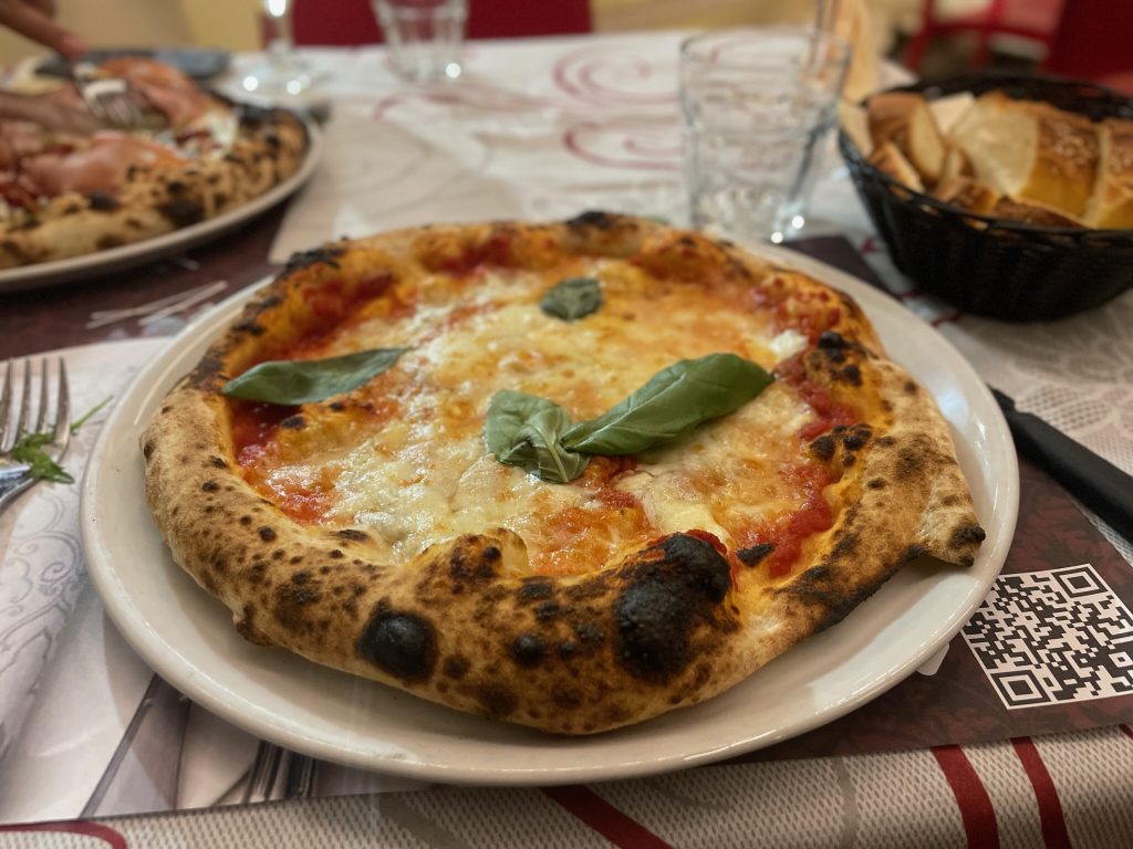 Delicious pizza garnished with a basil leaf.