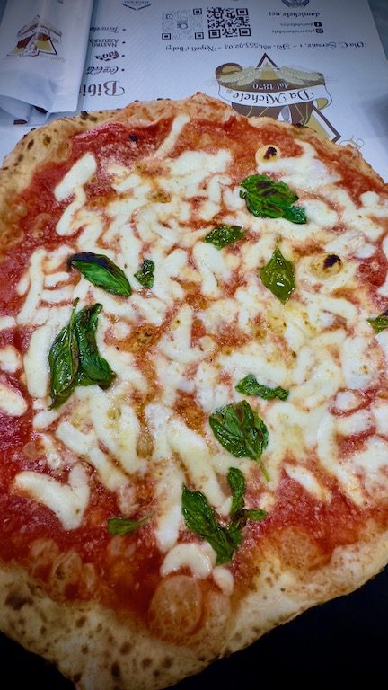 Pizza topped with cheese and basil.