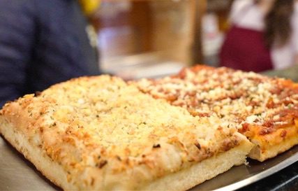 Square-shaped pizza topped with parmesan cheese.