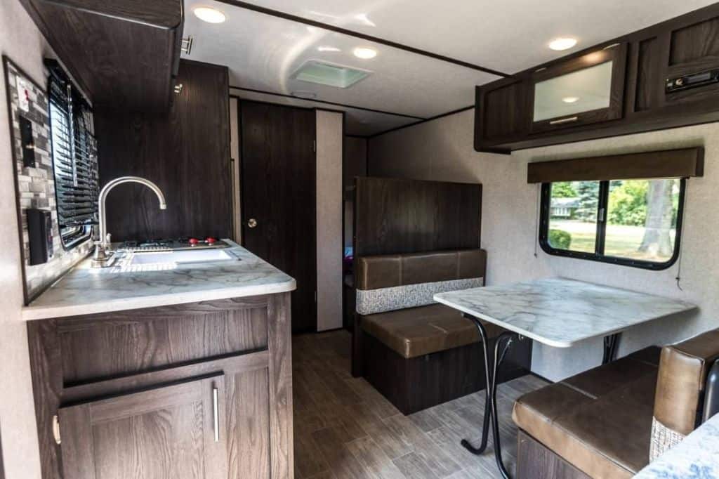 Interior of a travel trailer showing kitchen and seating area