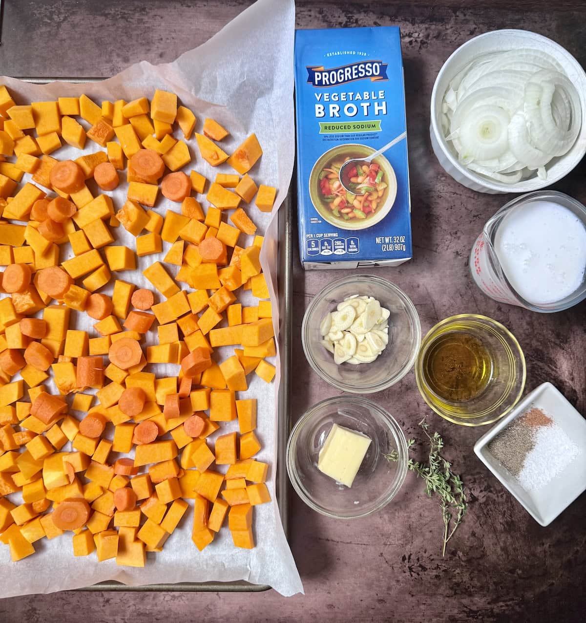 Ingredients for butternut squash soup laid out on a table.