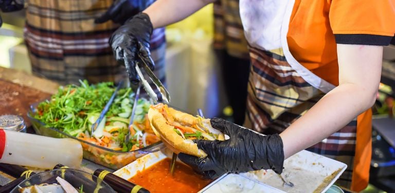 Vietnamese woman serving banh mi street food