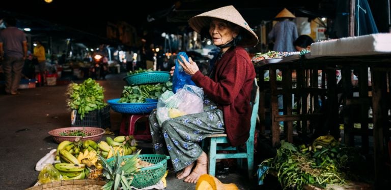 Street vendor at Vietnamese night market with local fruits and vegetables