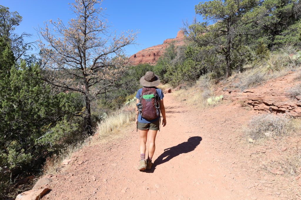 Woman hiking down red dirt trail in Sedona