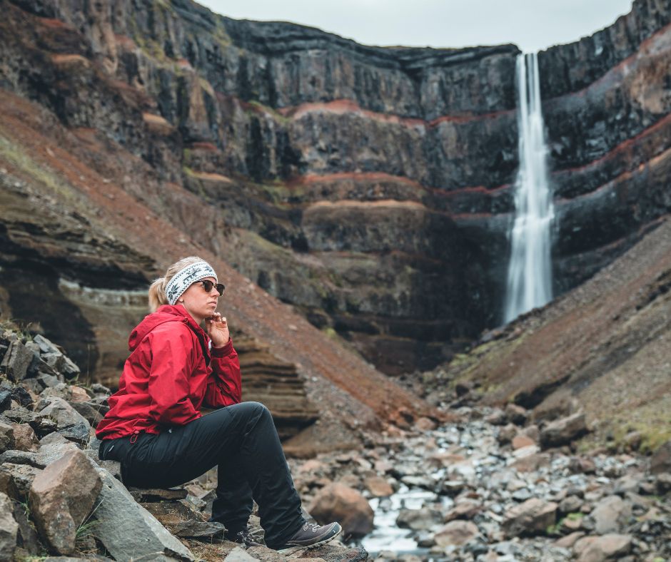 Jeannie sitting close to Hengifoss Waterfall in Iceland | Iceland with a View