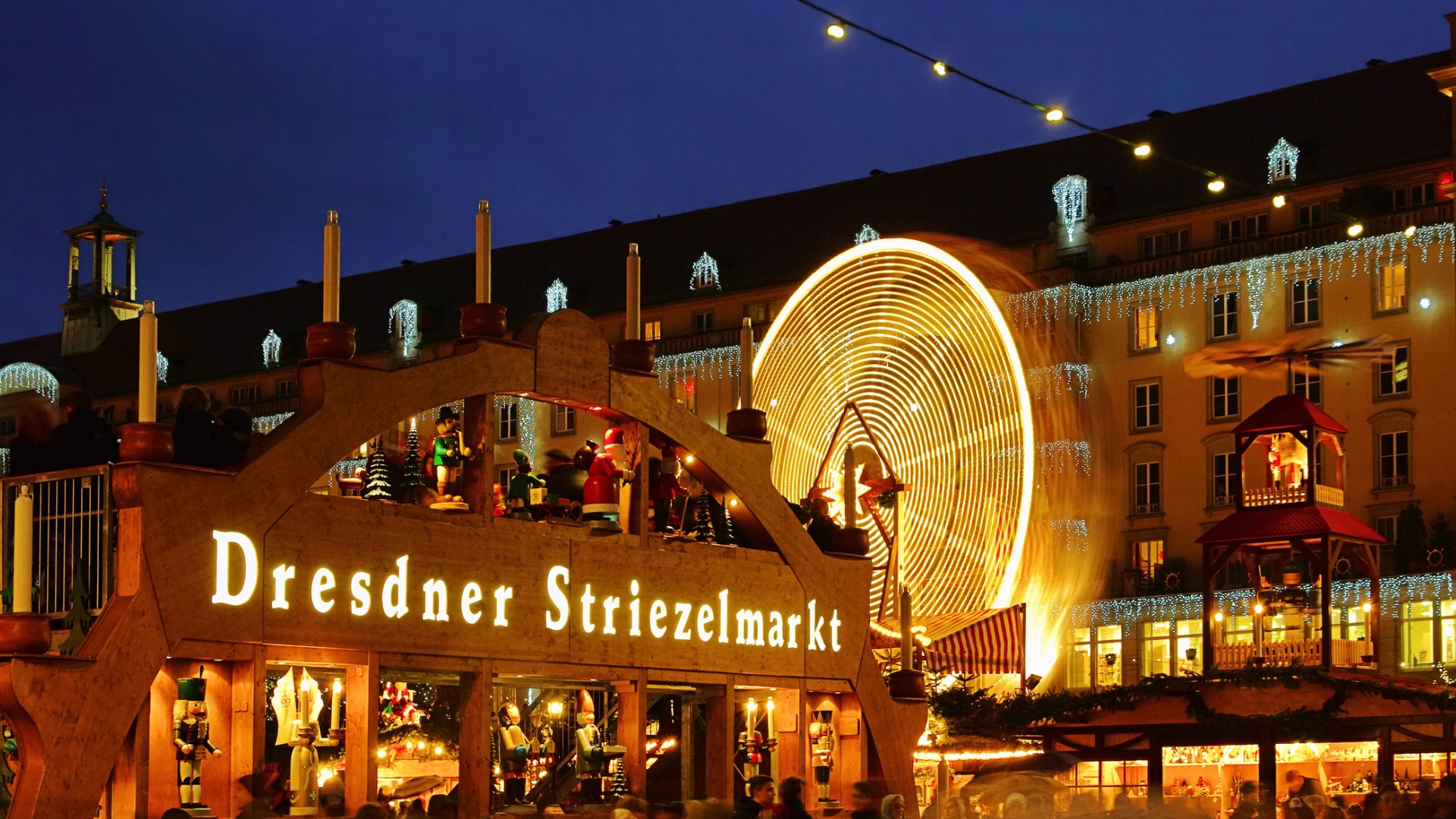 An illuminated wooden sign reading Dresdner Striezelmarkt, one of the best Christmas markets in Europe.